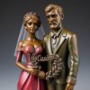 Cast bronze sculpture of a bride and groom, the groom looking mad, with a wreath inscribed Vay...jpg
